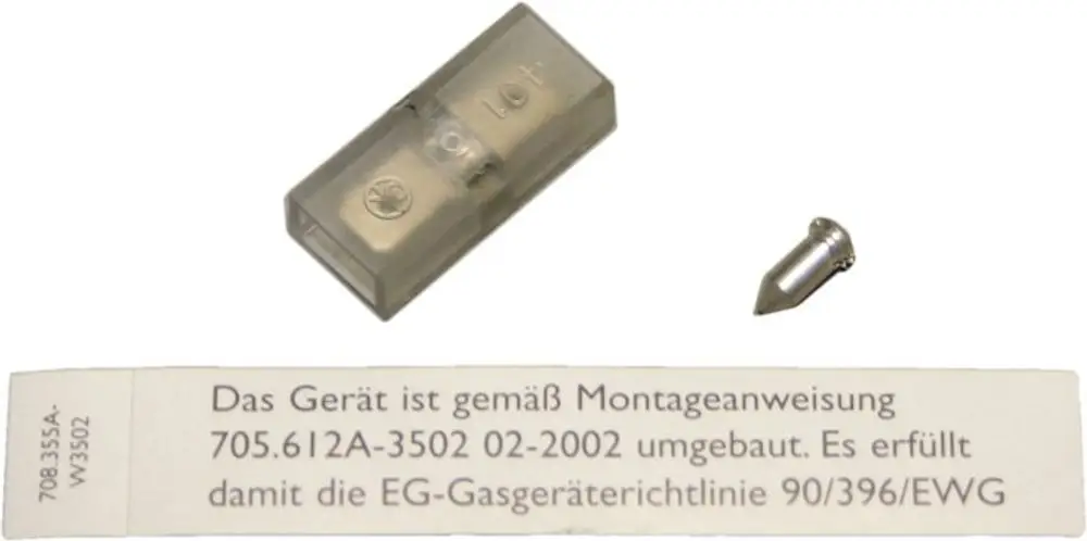 Ein transparentes Gehäuse mit einem kleinen Metallstift und einer Gebrauchsanweisung auf einem Papier, das die Umrüstung eines Bosch Gasdruckwächters beschreibt.